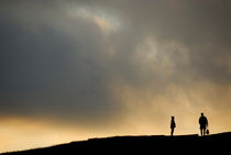 Silhouettes of two people standing on horizon von Sami Sarkis Photography