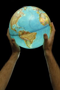 Man holding illuminated Earth globe by Sami Sarkis Photography