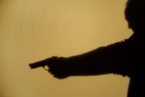 Shadow of man pointing gun by Sami Sarkis Photography