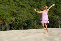 Little girl jumping in sand by Sami Sarkis Photography