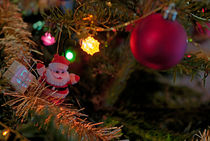 Baubles and Santa Claus on Christmas tree by Sami Sarkis Photography