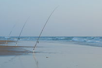 Three fishing rods on beach by Sami Sarkis Photography