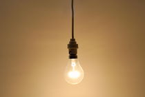Bare hanging light bulb by Sami Sarkis Photography