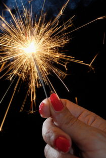 Woman holding sparkler by Sami Sarkis Photography