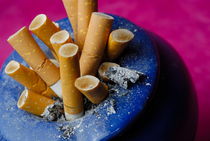 Cigarette butts in ashtray by Sami Sarkis Photography