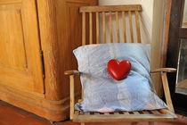 Heartshape and pillow on wooden rocking chair by Sami Sarkis Photography