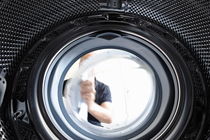Man opening a washing machine door by Sami Sarkis Photography