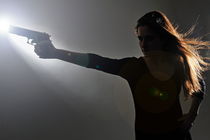 Young woman holding gun by Sami Sarkis Photography