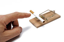 Man's hand about to catch cigarette on mousetrap by Sami Sarkis Photography