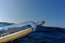 Bottle containing message floating in sea by Sami Sarkis Photography
