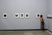 Woman watching photos at exhibition by Sami Sarkis Photography