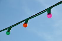 Three hanging colorful light bulbs by Sami Sarkis Photography