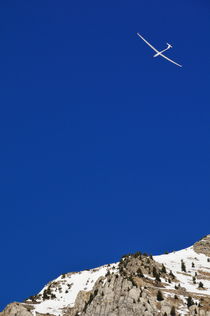 Glider flying over snowy mountain by Sami Sarkis Photography
