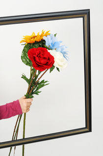 Hand of girl holding flowers over empty picture frame by Sami Sarkis Photography