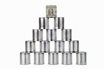Tin can surrounded by US dollar note on top of pyramid by Sami Sarkis Photography