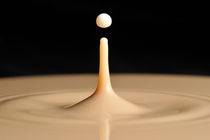 Drop of milk splashing into coffee by Sami Sarkis Photography