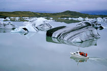 Tourist boat navigating through floating icebergs in the waters of Jokulsarlon by Sami Sarkis Photography