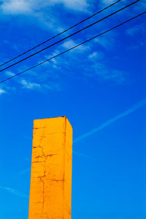 Tall brick chimney painted yellow. by Sami Sarkis Photography