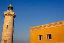 Lighthouse and yellow building at the entrance of the port von Sami Sarkis Photography