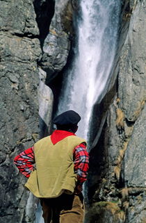 Man facing a waterfall. von Sami Sarkis Photography