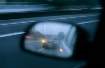 Speeding car on a highway reflected in the rear view mirror of another car von Sami Sarkis Photography