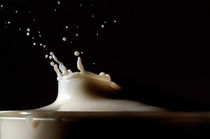 Drop of milk splashing in a glass. by Sami Sarkis Photography