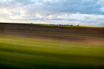 Blurred landscape seen from a speeding car on a country road by Sami Sarkis Photography