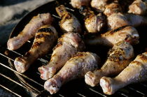 Chicken drumsticks being cooked on a barbecue for dinner. by Sami Sarkis Photography