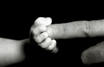 Father's finger touching his baby's foot. by Sami Sarkis Photography