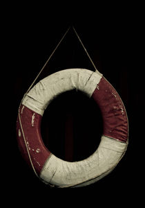 Life preserver hanging on a wall by Lars Hallstrom