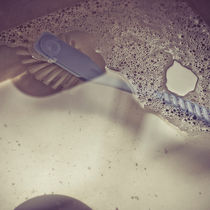 Dishbrush in sink by Lars Hallstrom
