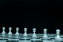 Playing pawns on chessboard by pbphotos