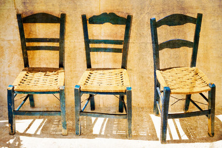 Three-blue-empty-wooden-chairs-on-sidewalk-in-matala-2
